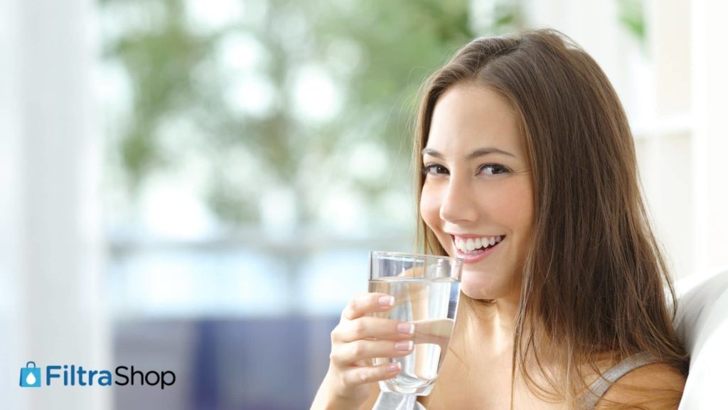 mujer tomando agua en un vaso